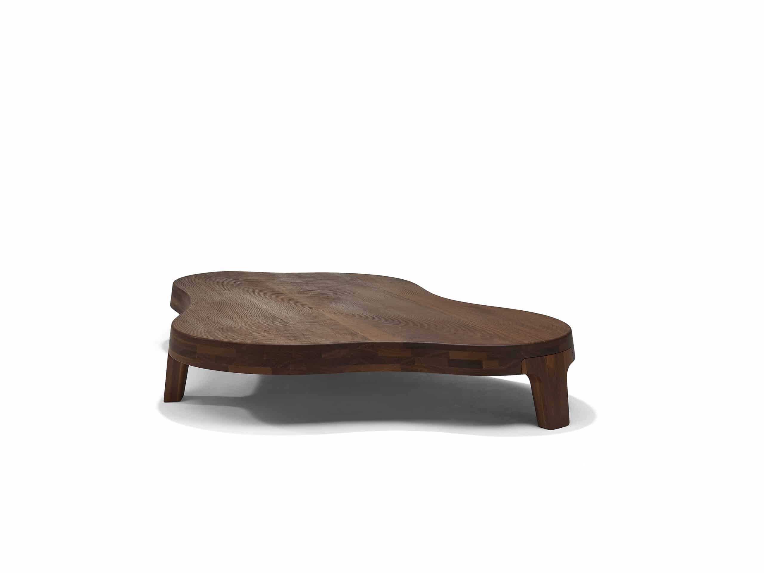 Linteloo Isola coffee table made of reddish brown sucupira wood, organically shaped like an island on three legs. The top of the coffee table is CNC milled to seem like the ridges left of the beach after the water draws back.