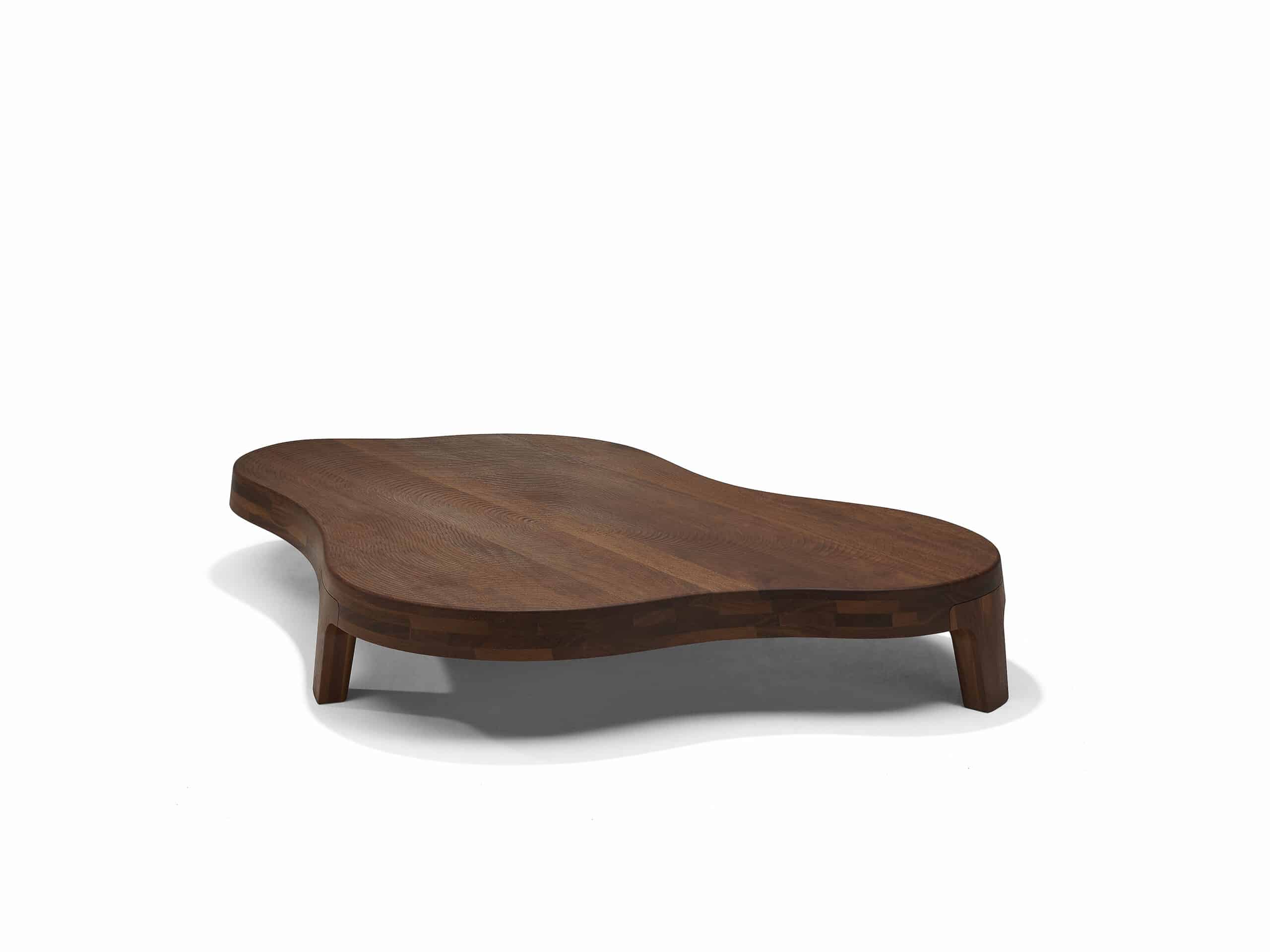 Linteloo Isola coffee table made of reddish brown sucupira wood, organically shaped like an island on three legs. The top of the coffee table is CNC milled to seem like the ridges left of the beach after the water draws back.