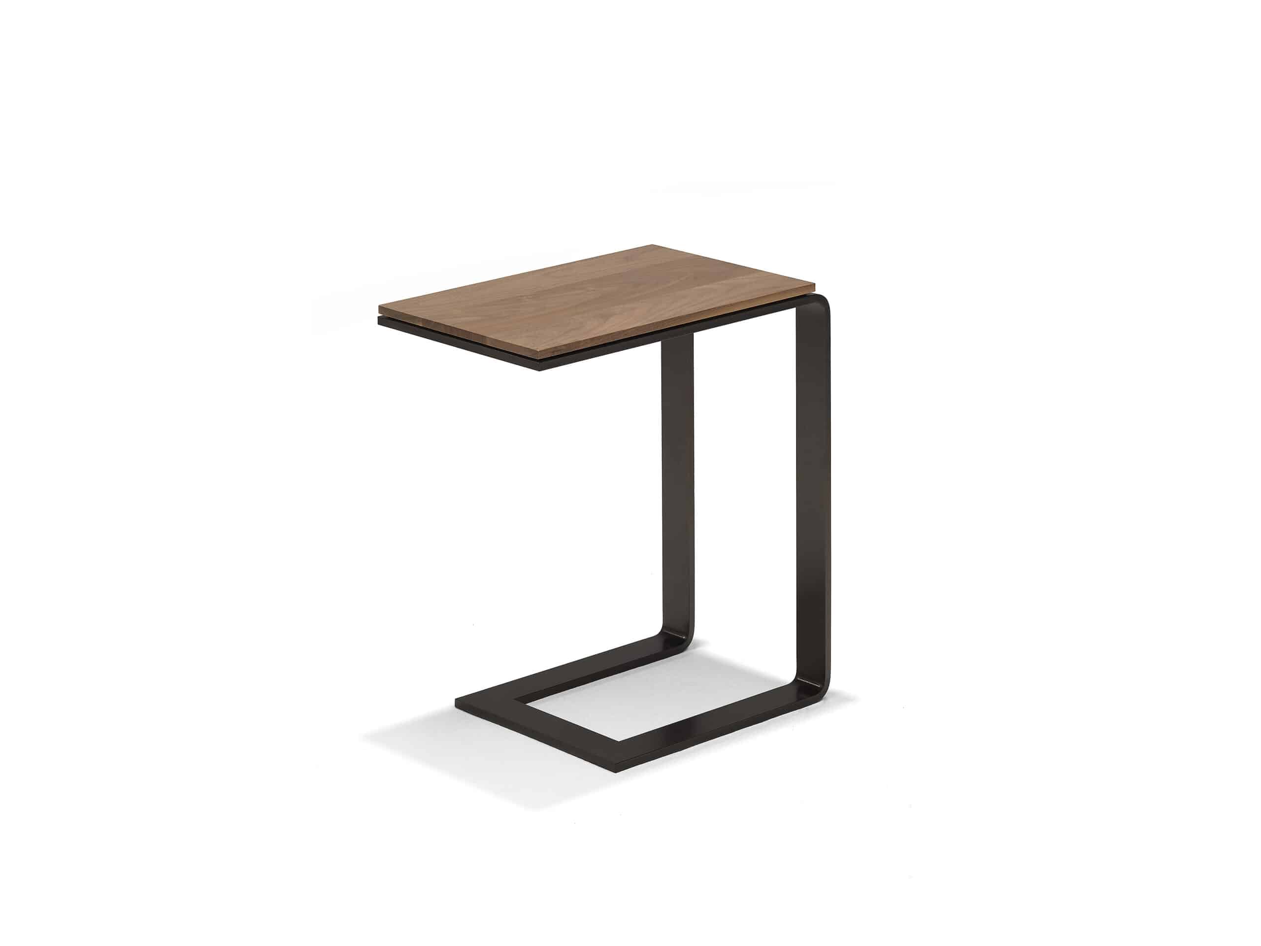 The Linteloo Malibu side table, made of metal U-shaped frame in a bronze or gunmetal finish and a walnut table top. Meant as a table that can slide under your sofa so you have a small table over the seat cushion.