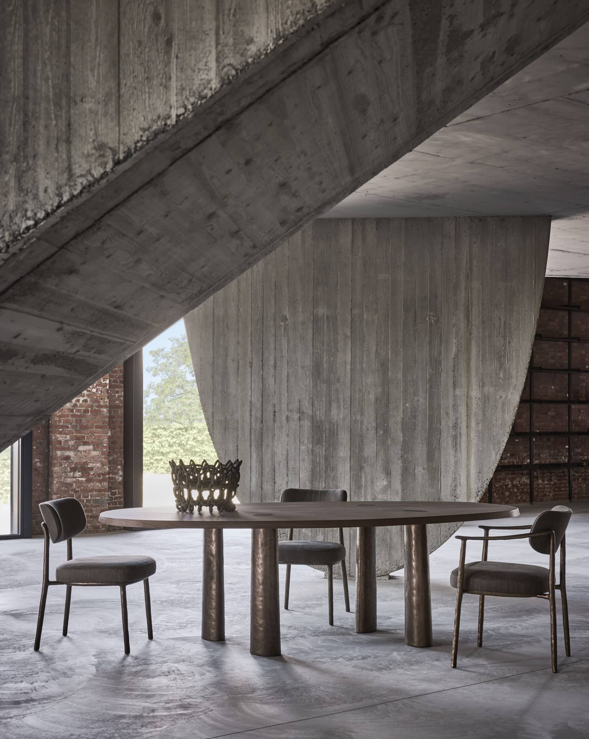 Linteloo Charles dining table and Gentle dining chairs / Linteloo Charles tafel en Gentle stoelen in an industrial space with concrete and exposed brick / in een industriële ruimte met beton en baksteen