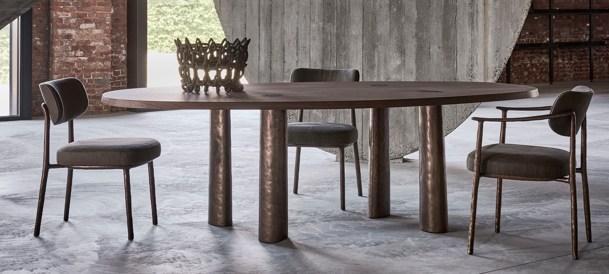 Linteloo Charles dining table and Gentle dining chairs / Linteloo Charles tafel en Gentle stoelen in an industrial space with concrete and exposed brick / in een industriële ruimte met beton en baksteen
