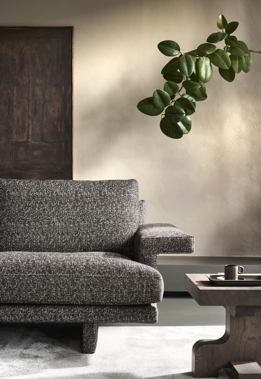 Linteloo Frank sofa, fully upholstered, even the legs, and with practical large armrests for your laptop, book or drink. Combined with a the Flux side table in a grey brown oak.