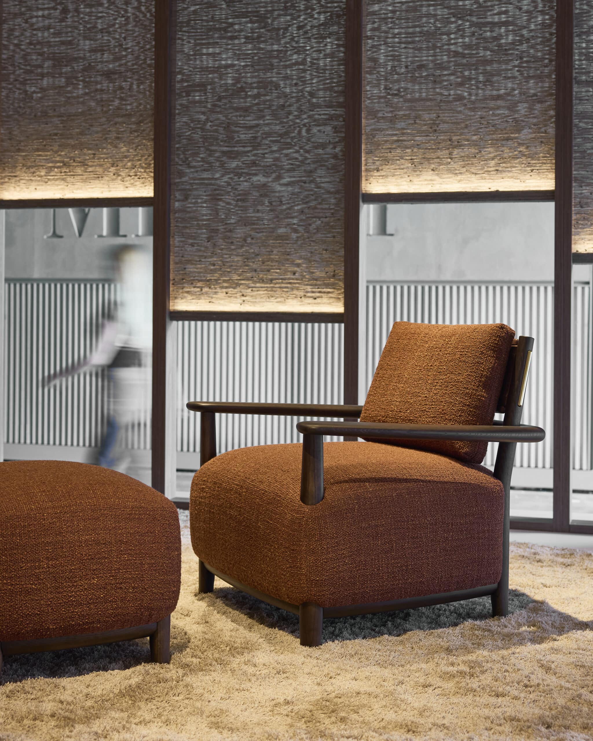 Linteloo Luc armchair and ottoman with a dark brown frame made of ash wood. The seat, back panel and back cushion are upholstered.