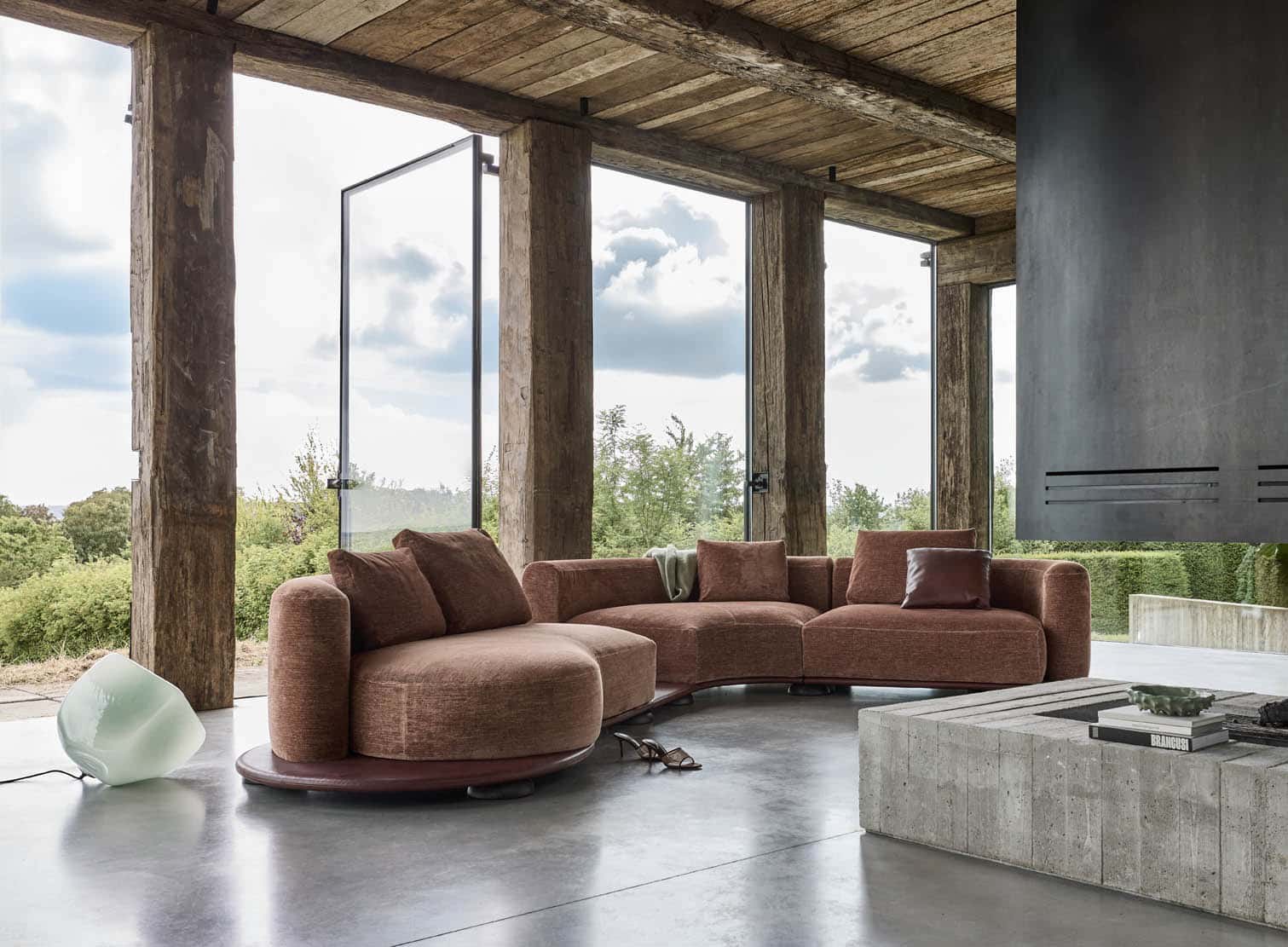 Linteloo Volta sofa in a brutalist home, an organic sofa on a leather base plateau. In a beautiful brick coloured fabric.