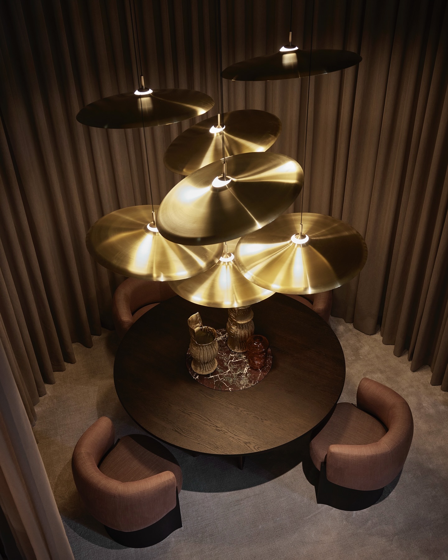 A dining area beneath a waterfall of gold. Introducing our second Salone del Mobile setting: ‘Tinza’ pendant lamps by Visser&Meijwaard, ‘Silva’ dining table (with a marble Lazy Susan!) and ‘Claude’ dining chairs, both designed by our new designer Guillaume Lopez. 

#linteloo #salonedelmobile #newcollection 

Gold vases: @ingebecka.artdesign @mariette.wolbert.textiles 
Glass vase: @studiorinkejoosten 

Photography: @alexandervanbergephotography 
Styling: @bregjenix @circlestudio.nl